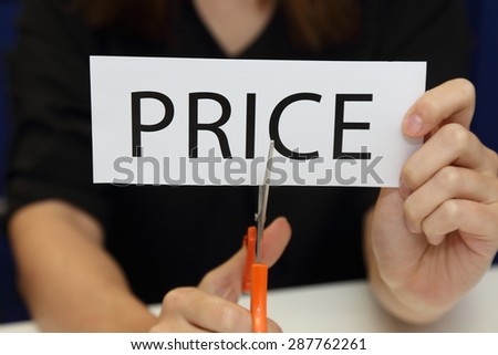 Closeup on woman cutting paper of price word