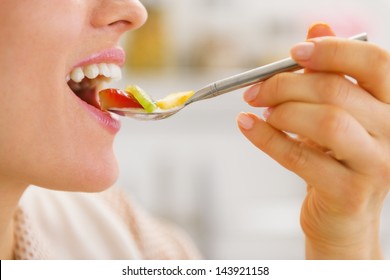 Closeup on woman eating fruits on spoon
