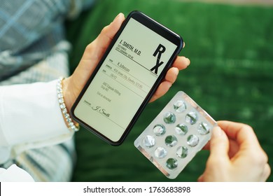 Closeup On Woman With Empty Blister Pack Of Pills And Electronic Prescription On A Smartphone In The House In Sunny Day.