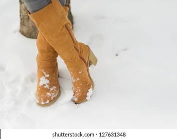 Closeup On Woman Legs In Winter Boots On Snow