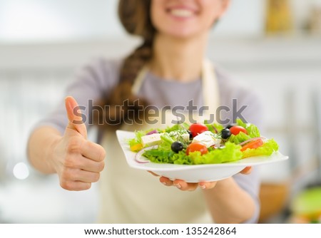 Closeup on woman showing fresh salad and thumbs up
