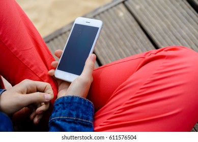 Closeup On Woman Sitting Using Mobile Phone. Portable Computer Mockup Display On Outdoors Background