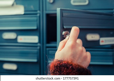 Closeup on a woman's hand as she is getting her post out of her letterbox