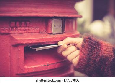 Closeup on a woman's hand as she is posting a letter