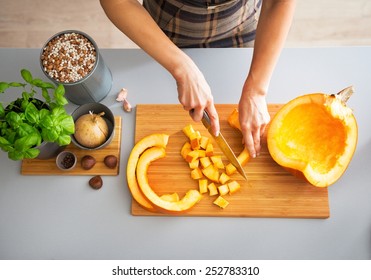 Closeup on young housewife cutting pumpkin