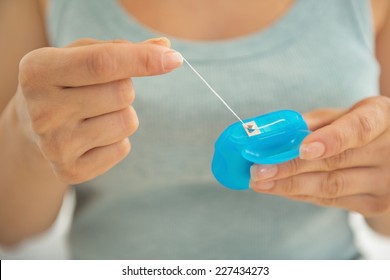 Closeup On Young Woman Holding Dental Floss