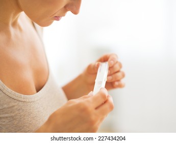 Closeup on young woman looking on pregnancy test