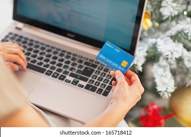 Closeup On Young Woman Making Online Shopping Near Christmas Tree