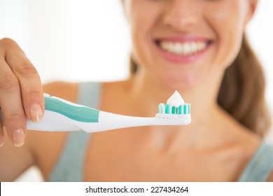 Closeup on young woman showing electric toothbrush