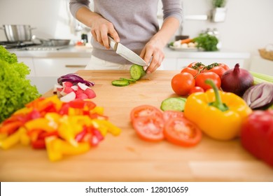 Closeup on young woman slicing vegetables - Shutterstock ID 128010659