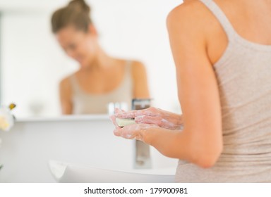 Closeup On Young Woman Washing Hands In Bathroom With Soap Bar