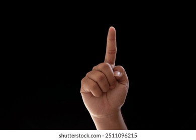 Close-up of one hand pointing or indicating the number one. Isolated photo on black background - Powered by Shutterstock