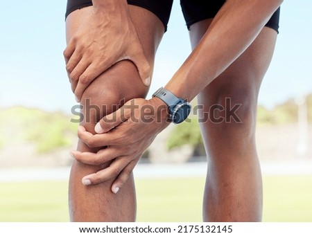Closeup of one man holding sore knee from exercising outdoors. Uncomfortable athlete suffering with painful leg injury, fractured joint and inflamed muscles during workout. Strain due to overexertion Stockfoto © 