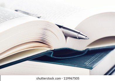 Close-up Of Open Book And Pen