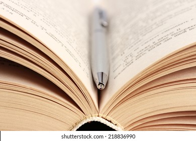 Close-up Of Open Book And Pen