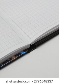 Close-up of an open checkered notebook or copybook on a white background