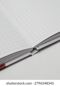 Close-up of an open checkered notebook or copybook on a white background