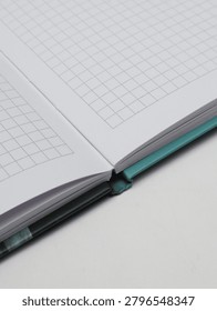 Close-up of an open checkered notebook or copybook on a white background