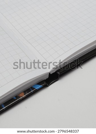 Close-up of an open checkered notebook or copybook on a white background