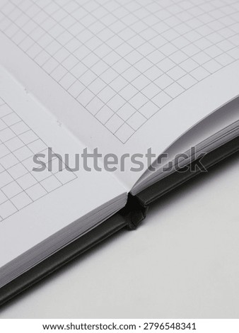Close-up of an open checkered notebook or copybook on a white background