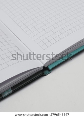 Close-up of an open checkered notebook or copybook on a white background