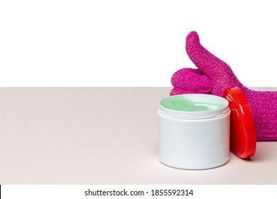 Closeup Of An Open Container With Cooling Gel (horse Balm) For Sports Injuries And A Pink Massage Glove With A Thumbs Up On Bright Table Isolated On A White Background. Space.