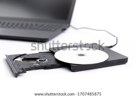 closeup of an open external DVD player attached to a black notebook computer isolated on white