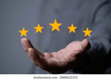 Close-up of an open hand displaying five glowing star rating icons, symbolizing customer satisfaction, positive feedback, quality service, online review, user experience, business evaluation concepts.