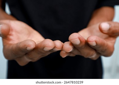 Close-up of open hands presenting or offering, dark-skinned person, isolated on white indoors