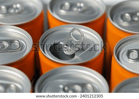 closeup open ring on orange aluminum soda drink' can. Recycling aluminum or metal empty cans from above. Group of cans for reuse and recycle.