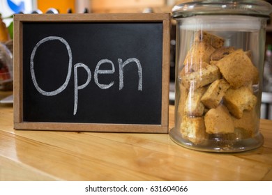 Close-up of open sign by cookies in jar on counter at coffee shop - Powered by Shutterstock