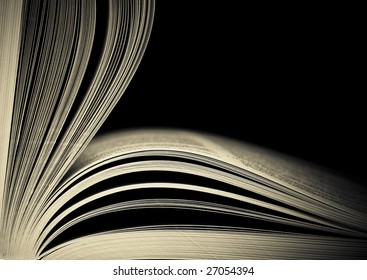 Close-up of opened book pages against black background. Space for text. Shallow DOF.