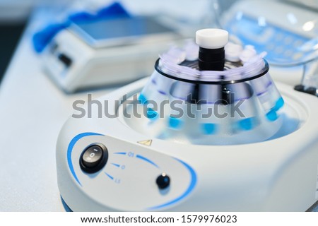 Close-up of opened laboratory centrifuge with samples inside of rotating units used for separating liquids.Close up of a chemist using a centrifuge rotor in lab  for medical and scientific research.