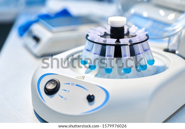 Close-up of opened laboratory centrifuge with\
samples inside of rotating units used for separating liquids.Close\
up of a chemist using a centrifuge rotor in lab  for medical and\
scientific research.