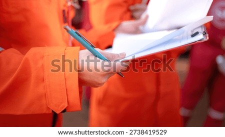 Close-up at operation supervisor hand in action of checking on the document and certification during perform safety audit at construction working site. Industrial working scene.