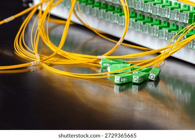 Close-up of an optical fiber patch panel with connected patch cords and SC APC connectors during installation in a passive optical network, representing modern telecommunications and data transmission infrastructure.