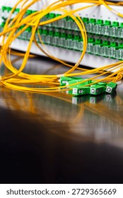 Close-up of an optical fiber patch panel with connected patch cords and SC APC connectors during installation in a passive optical network, representing modern telecommunications and data transmission infrastructure.
