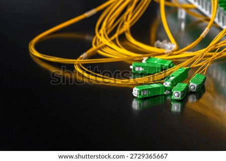 Close-up of an optical fiber patch panel with connected patch cords and SC APC connectors during installation in a passive optical network, representing modern telecommunications and data transmission infrastructure.