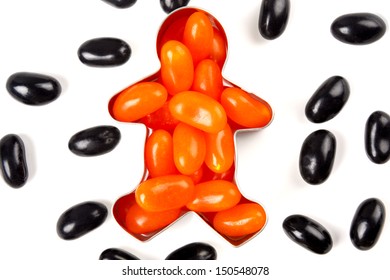 Closeup Of Orange Jelly Bean Man With Black Jelly Beans Scatted Around For Halloween Concept