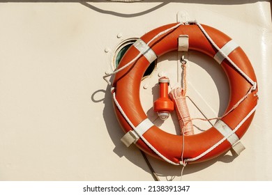 Close-up of an orange life buoy with an emergency light for localization on a boat deck with copy space. - Powered by Shutterstock