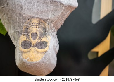 Closeup Orange Skull Hanging With White Cloak. Halloween Decoration Concept.