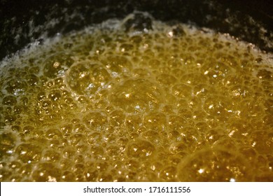 closeup ov bubbles of golden melted butter while making home made ghee clarified butter