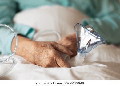 Close-up of oxygen mask holding by eldery patient. Home oxygen therapy. - Powered by Shutterstock