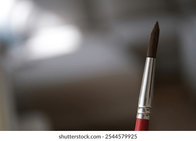 A close-up of a paintbrush with a blurred background, symbolizing creativity, art, and the tools of an artist - Powered by Shutterstock