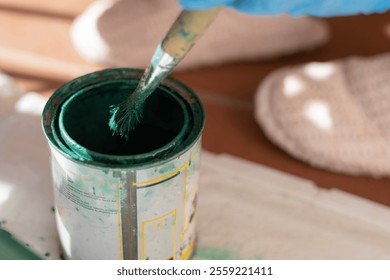 Close-up of a paintbrush dipped in green paint, capturing the texture of the paint during a restoration process. - Powered by Shutterstock