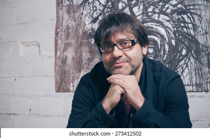Closeup of painter artist posing in front of one modern artwork in his studio - Shutterstock ID 273412502