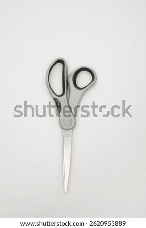 Close-up of a pair of grey and silver scissors on a white surface close-up photo macro view