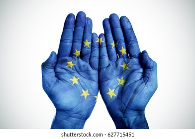closeup of the palms of a man put together patterned with the flag of the european community on an off-white background, with a slight vignette added - Shutterstock ID 627715451