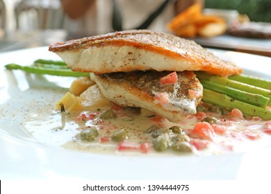 Closeup Pan Seared Sea Bass With Tomato Caper Mustard Cream Sauce