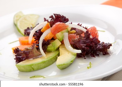 Closeup of papaya, avocado and grapefruit salad with sweet onion and lime wedges - Powered by Shutterstock